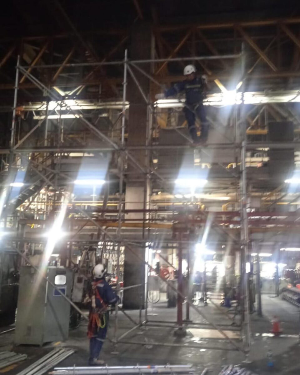 Montaje de andamios en planta industrial durante turno de noche